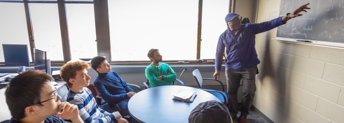 Herbert Fotso, with physics teaches in a graduate study meeting in Fronczak Hall in February 2024. 