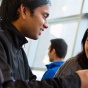 students talking in front of a laptop. 